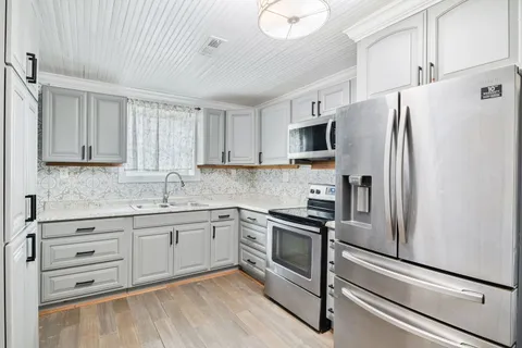 a kitchen with stainless steel appliances white cabinets and a refrigerator