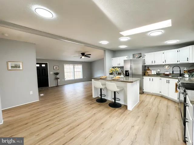 a kitchen with a refrigerator and wooden floor