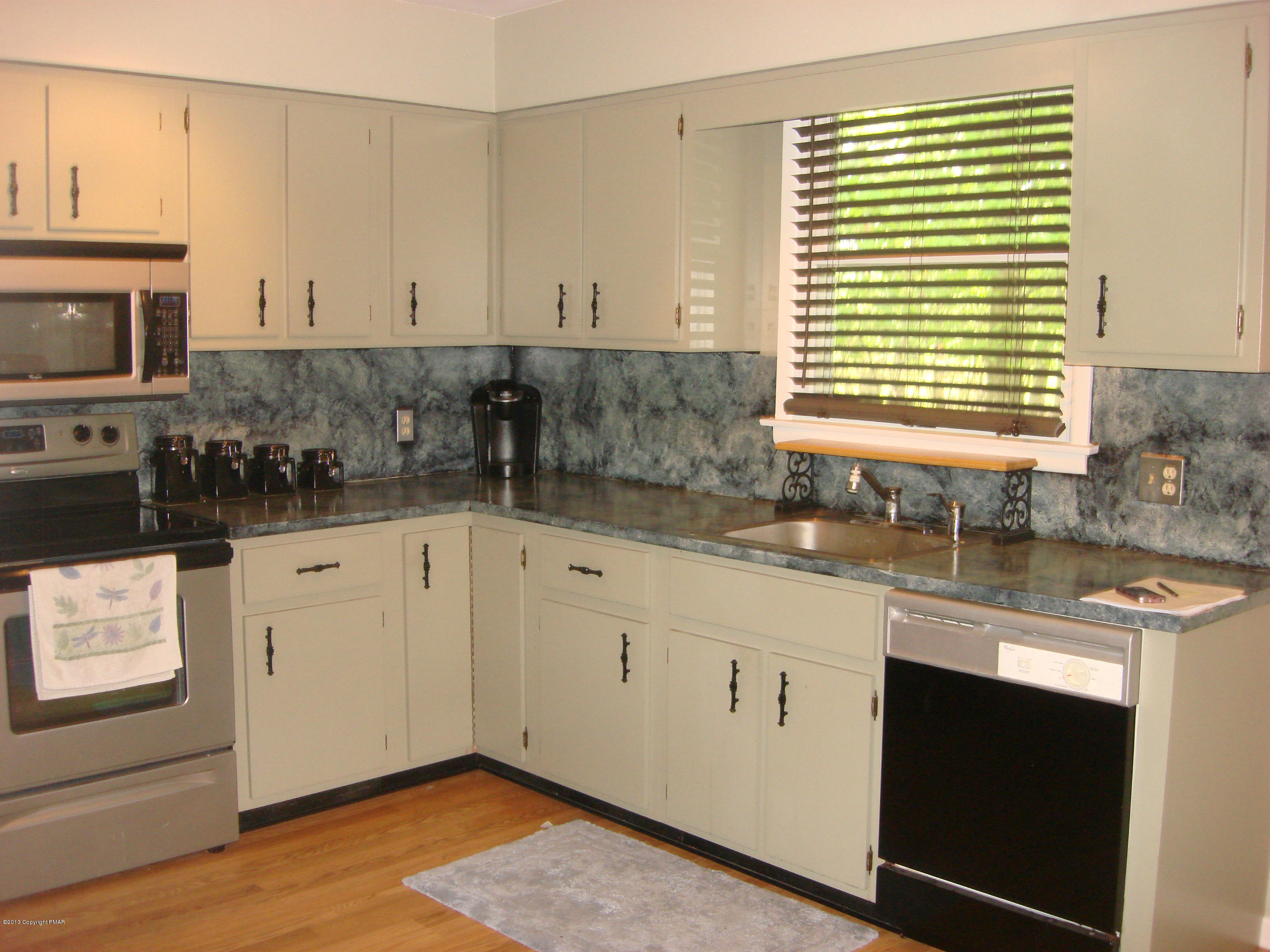 5 Laurelwood Road Swiftwater, PA 18370 - Photo 5 of 17 a kitchen with stainless steel appliances granite countertop a sink and cabinets with wooden floor