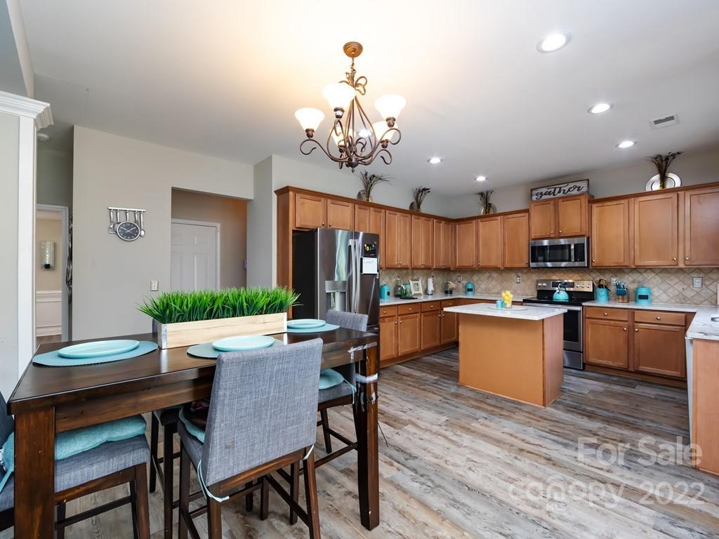 2721 Gosling Terrace Road Charlotte, NC 28262 - Photo 12 of 29 a kitchen with kitchen island a dining table and chairs