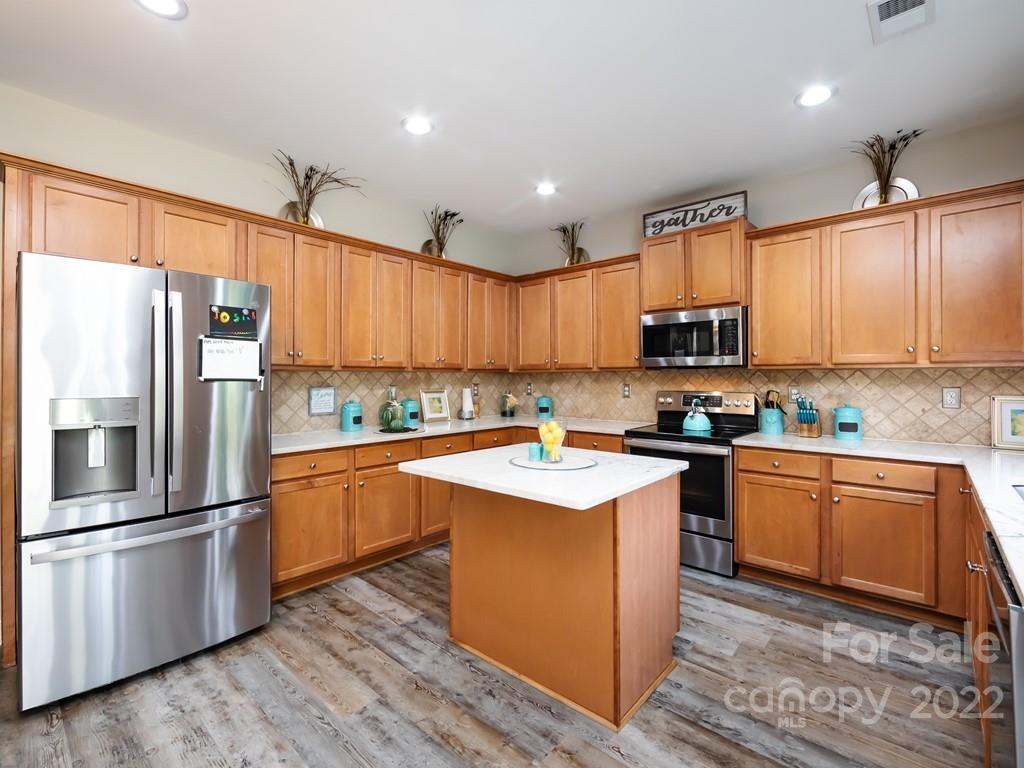 2721 Gosling Terrace Road Charlotte, NC 28262 - Photo 13 of 29 a kitchen with stainless steel appliances granite countertop a refrigerator a sink dishwasher a stove top oven a refrigerator and cabinets with wooden floor