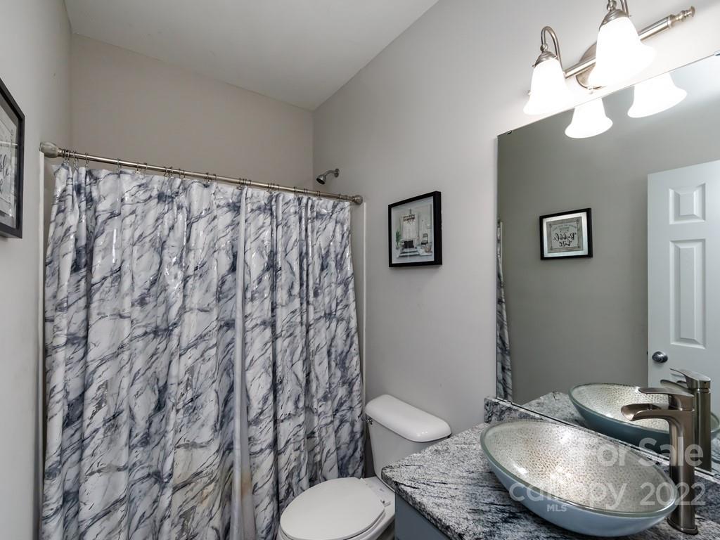 2721 Gosling Terrace Road Charlotte, NC 28262 - Photo 10 of 29 a bathroom with a granite countertop toilet and a sink