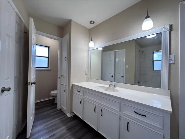 a spacious bathroom with a granite countertop sink mirror and toilet