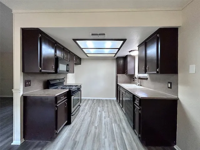 a kitchen with stainless steel appliances granite countertop a sink stove and cabinets