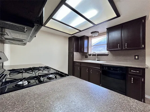 a kitchen with a stove a sink and a microwave