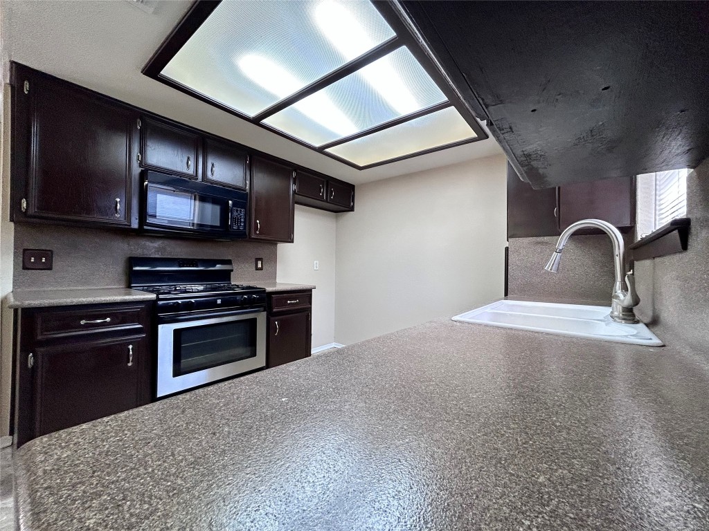 906 Spring Tree Street Round Rock, TX 78681 - Photo 6 of 18 a kitchen with stainless steel appliances and a stove top oven