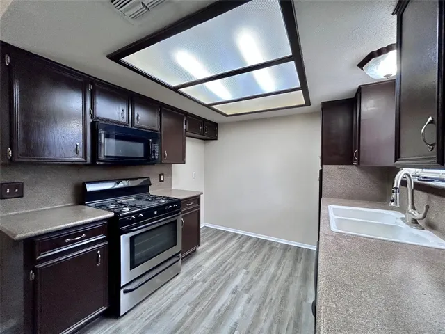 a kitchen with stainless steel appliances granite countertop a stove and a sink