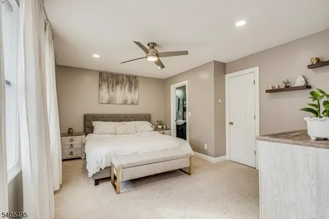 a bedroom with a large bed and a chandelier fan