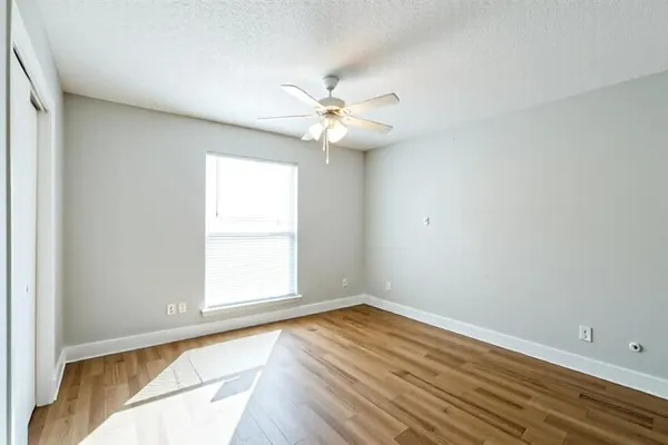 an empty room with a window and a ceiling fan