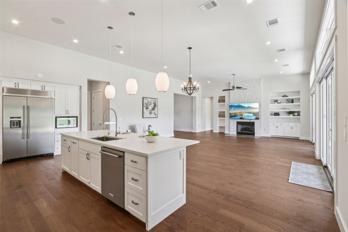 2404 Sailboat Pass Spicewood, TX 78669 - Photo 11 of 39 a large kitchen with stainless steel appliances a large counter top a stove a refrigerator and a view of living room