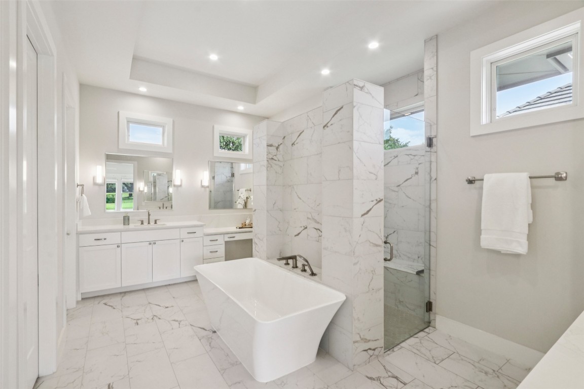 2404 Sailboat Pass Spicewood, TX 78669 - Photo 18 of 39 a bathroom with a granite countertop sink a toilet a mirror and shower