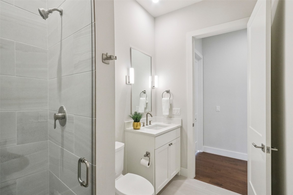 2404 Sailboat Pass Spicewood, TX 78669 - Photo 24 of 39 a bathroom with a sink vanity granite toilet and shower