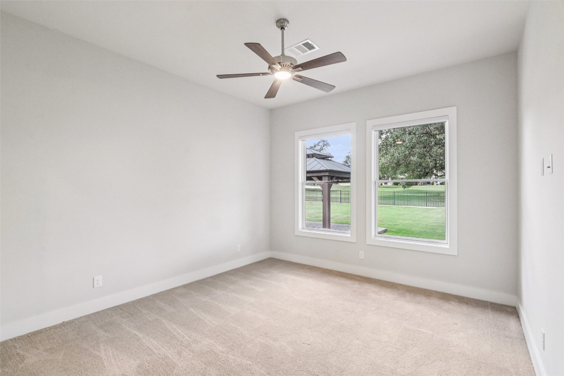 2404 Sailboat Pass Spicewood, TX 78669 - Photo 25 of 39 an empty room with windows and ceiling fan