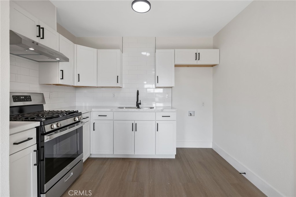 412 East Fairview Road Bakersfield, CA 93307 - Photo 13 of 28 a kitchen with stainless steel appliances granite countertop a stove a sink and white cabinets