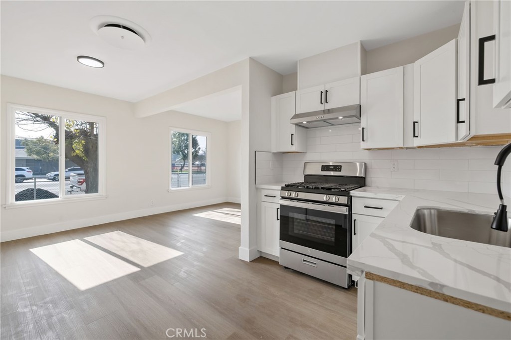 412 East Fairview Road Bakersfield, CA 93307 - Photo 15 of 28 a kitchen with granite countertop a stove and a sink