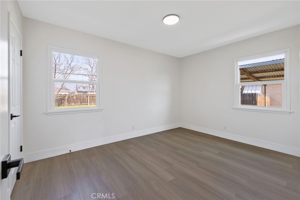 412 East Fairview Road Bakersfield, CA 93307 - Photo 20 of 28 a view of an empty room with wooden floor and a window