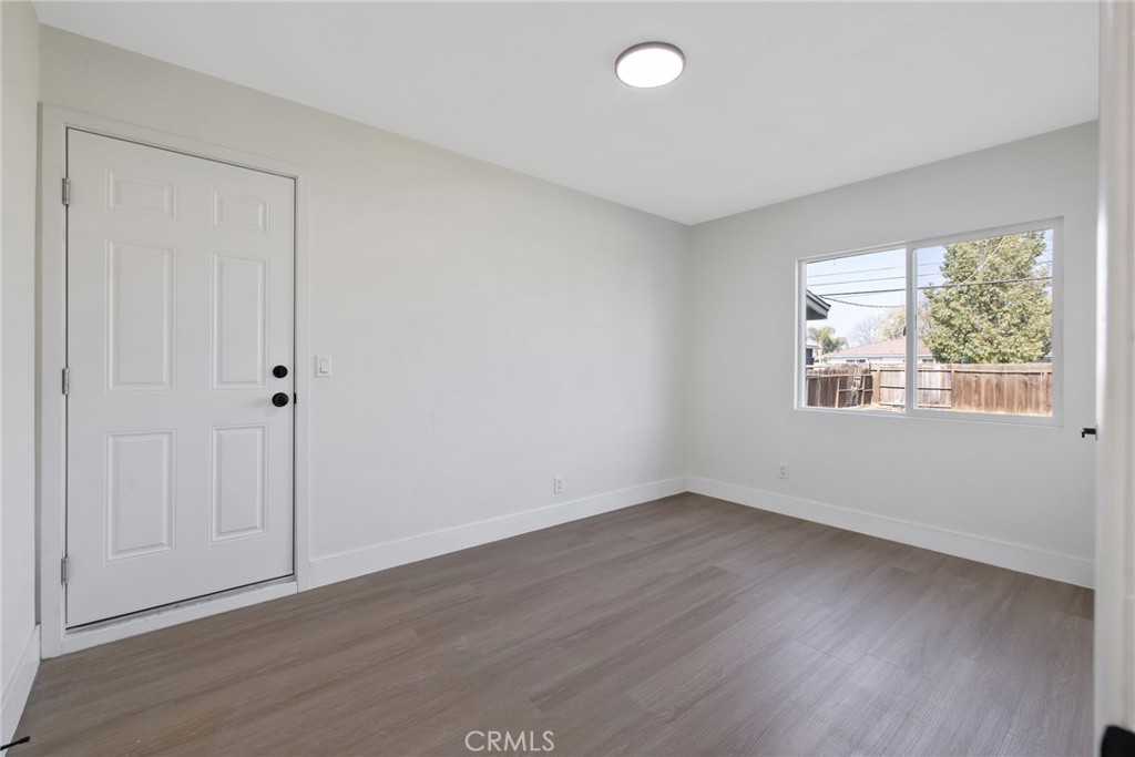 412 East Fairview Road Bakersfield, CA 93307 - Photo 22 of 28 an empty room with wooden floor and windows