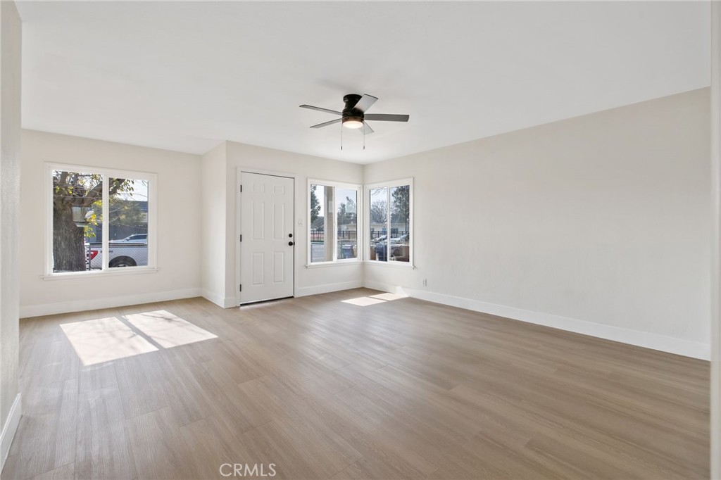 412 East Fairview Road Bakersfield, CA 93307 - Photo 7 of 28 an empty room with wooden floor ceiling fan and windows