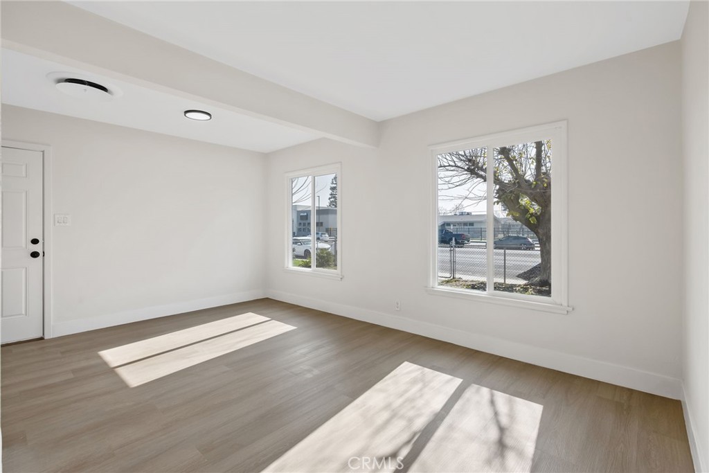412 East Fairview Road Bakersfield, CA 93307 - Photo 9 of 28 an empty room with wooden floor and windows
