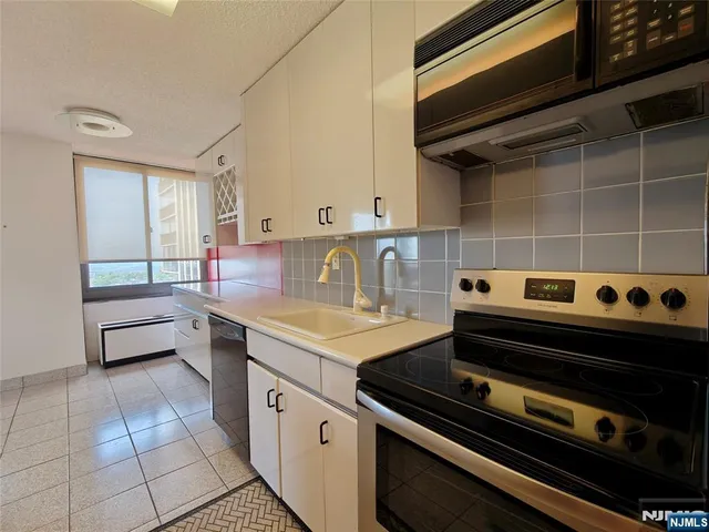 a kitchen with a stove a sink and cabinets