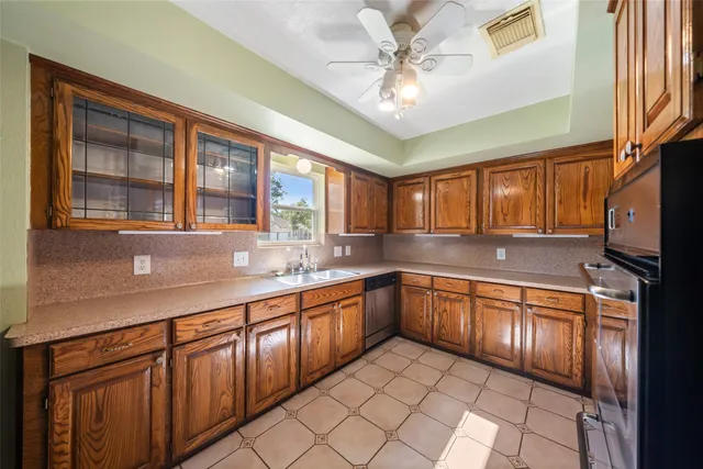a kitchen with stainless steel appliances granite countertop a refrigerator a stove and a sink with wooden floor