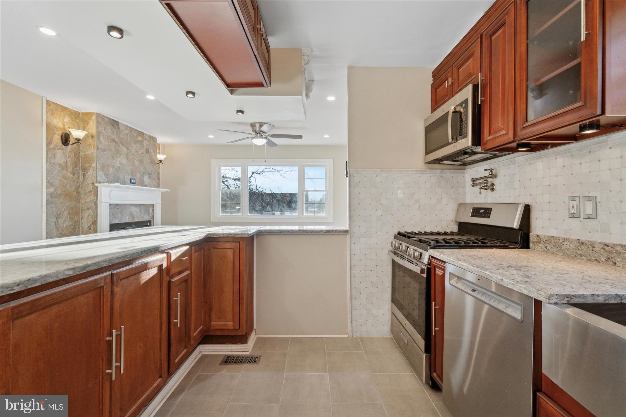 709 Chandler Street Philadelphia, PA 19111 - Photo 11 of 31 a kitchen with stainless steel appliances granite countertop a stove a sink and a microwave