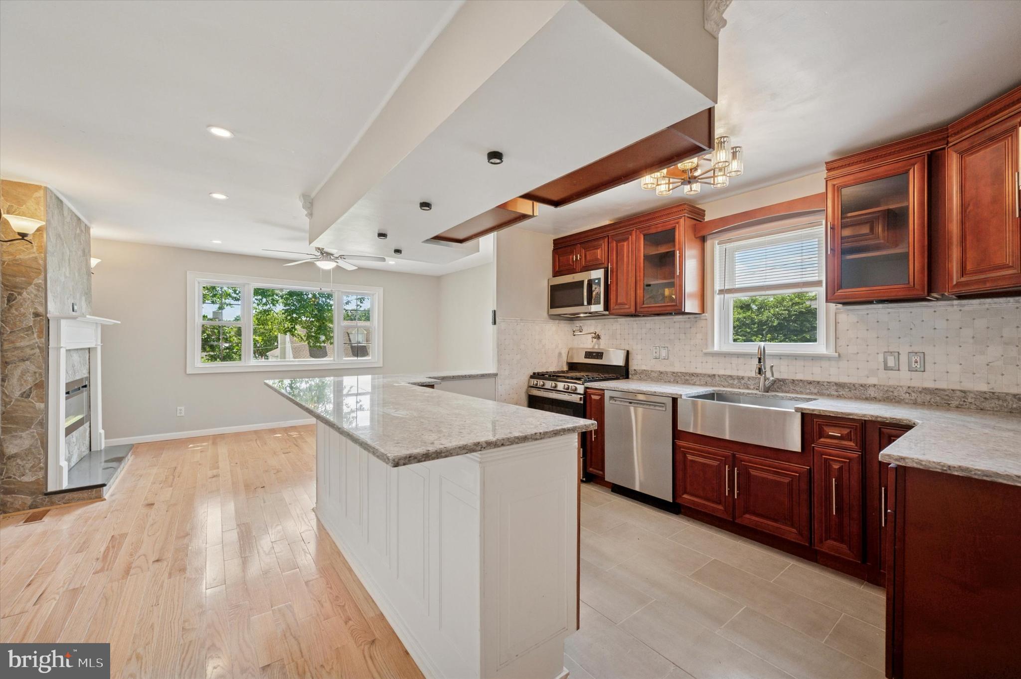 709 Chandler Street Philadelphia, PA 19111 - Photo 8 of 31 a kitchen with granite countertop a sink stove and wooden cabinets