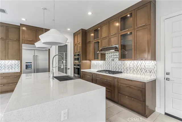 a kitchen with stainless steel appliances granite countertop a sink and a refrigerator