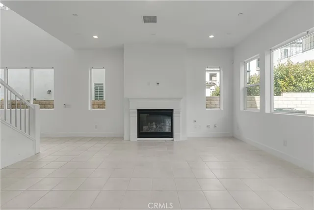 an empty room with windows and fireplace