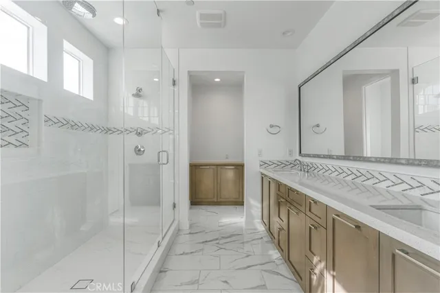 a bathroom with a granite countertop sink a mirror and a shower