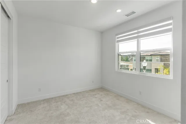an empty room with cabinet and mirrors