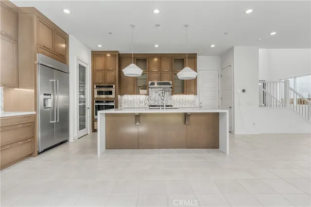a large kitchen with stainless steel appliances a large counter top