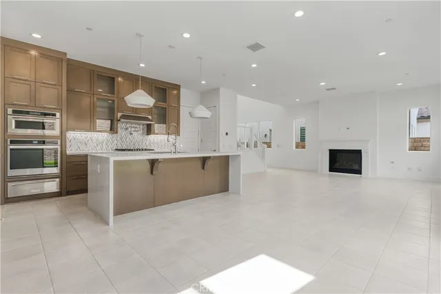 a large white kitchen with a large window and stainless steel appliances