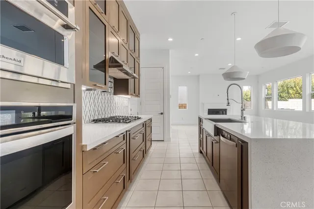 a kitchen with stainless steel appliances granite countertop a sink a stove and a refrigerator