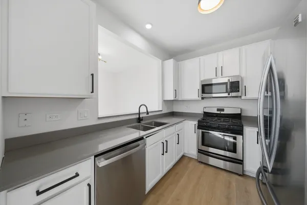 a kitchen with stainless steel appliances granite countertop a sink stove and refrigerator