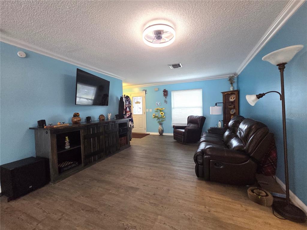 4059 Ligonier Road Spring Hill, FL 34608 - Photo 11 of 36 a living room with furniture and a flat screen tv