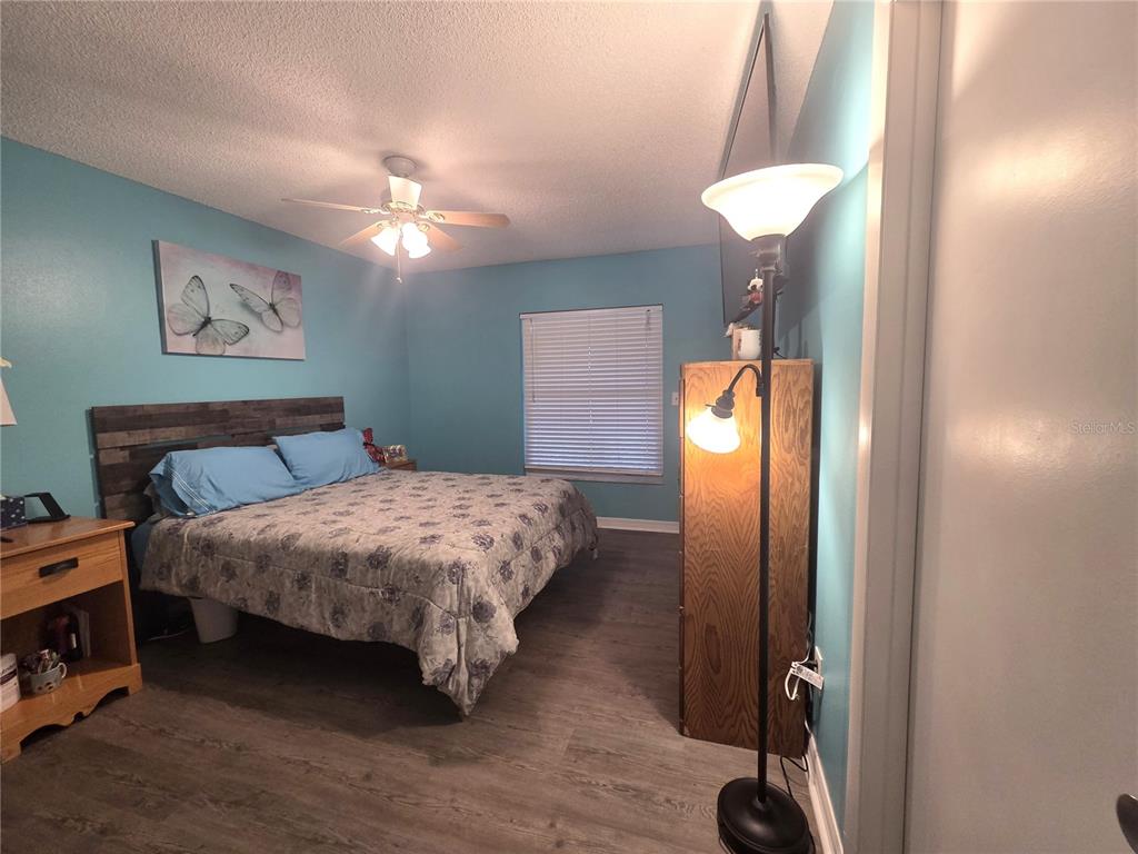 4059 Ligonier Road Spring Hill, FL 34608 - Photo 14 of 36 a bedroom with a bed and a chandelier