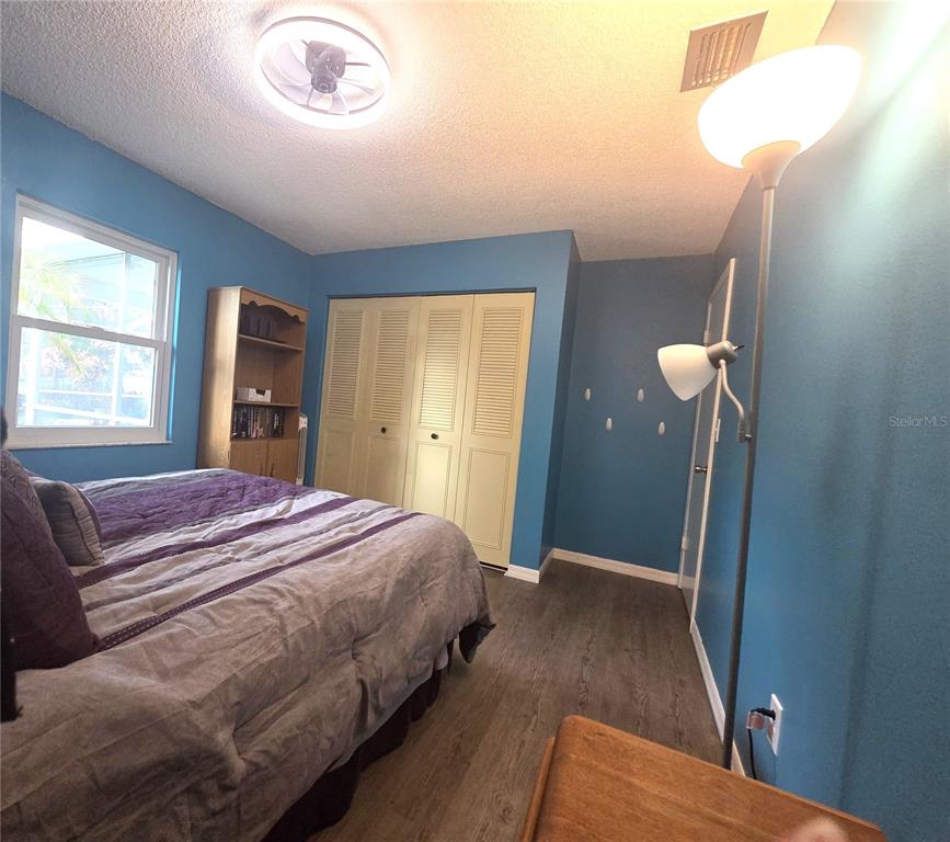 4059 Ligonier Road Spring Hill, FL 34608 - Photo 22 of 36 a bedroom with a bed and a chandelier