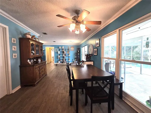 a kitchen with stainless steel appliances granite countertop a dining table chairs and granite counter tops