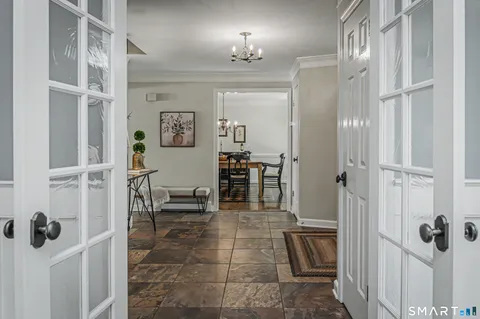 a view of a hallway with dining room and furniture