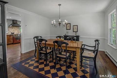 a dining room with furniture a chandelier and wooden floor