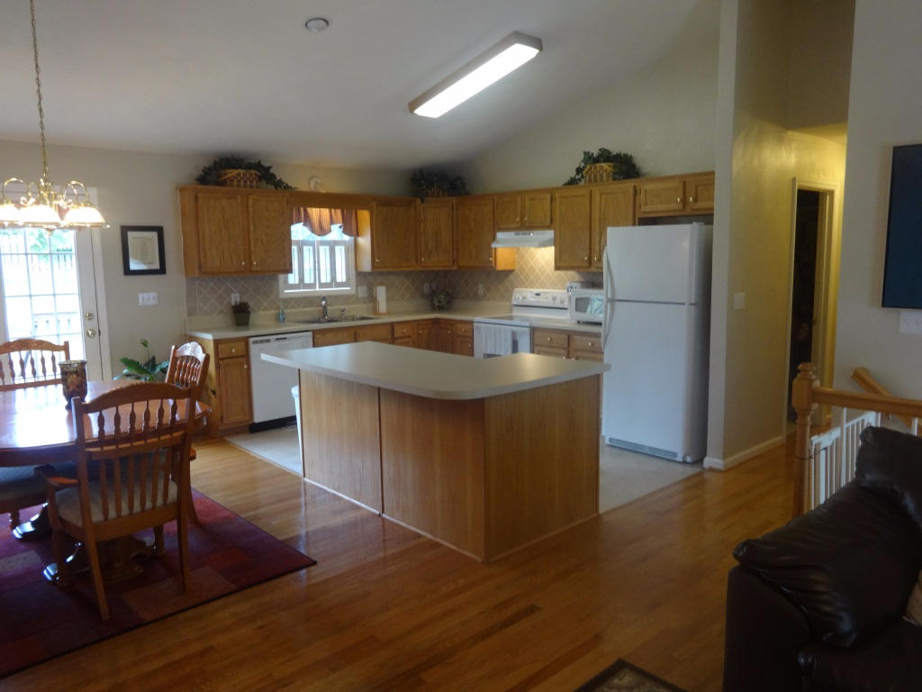 1732 Meadows Road Vinton, VA 24179 - Photo 16 of 32 a kitchen with granite countertop a refrigerator a stove a dining table and chairs with wooden floor