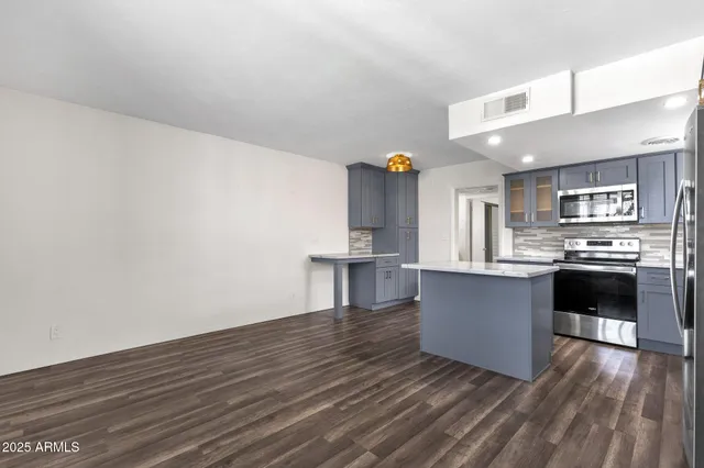 a kitchen with stainless steel appliances a refrigerator and a stove top oven