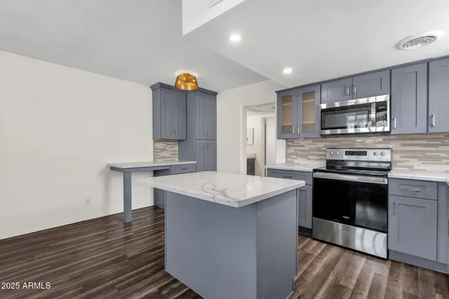 a kitchen with stainless steel appliances granite countertop a sink stove and oven