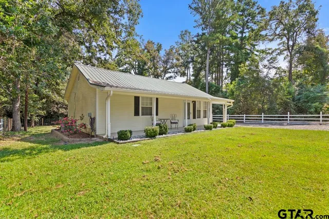a view of a house with a yard and sitting area