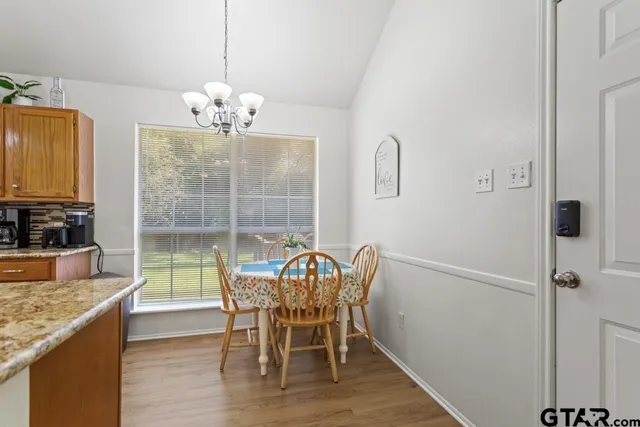 a view of a dining room with furniture a chandelier and wooden floor