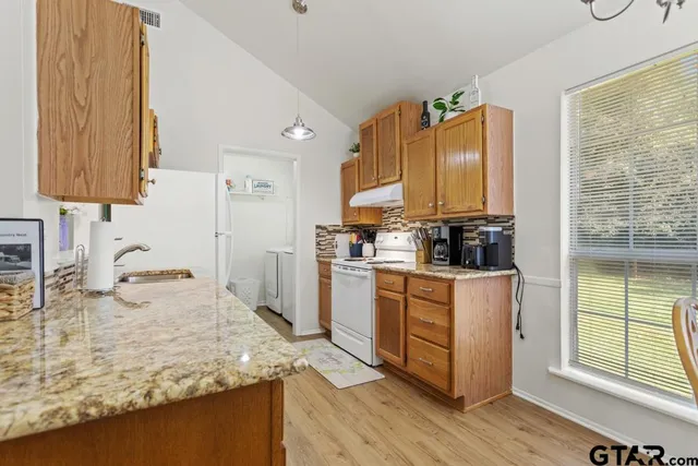 a kitchen with stainless steel appliances granite countertop a stove a sink and a refrigerator