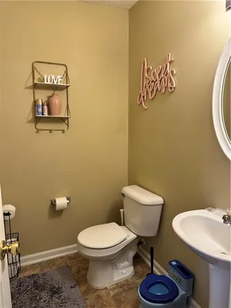 a bathroom with a toilet a sink and mirror