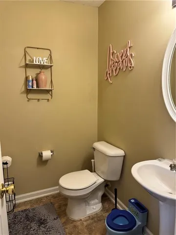a bathroom with a toilet a sink and mirror