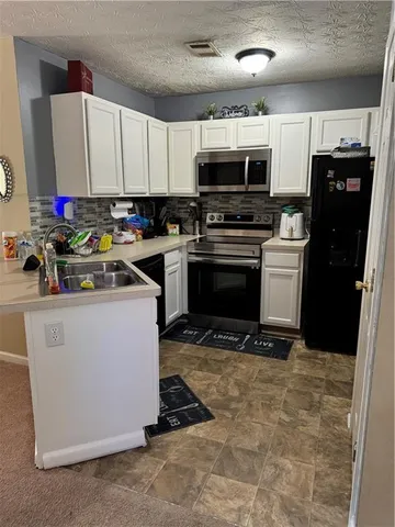 a kitchen with stainless steel appliances a stove a microwave and a refrigerator